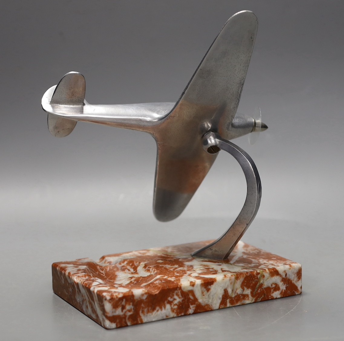 A mid 20th century aluminium model of a spitfire on ashtray marble base, spitfire 17cms wide